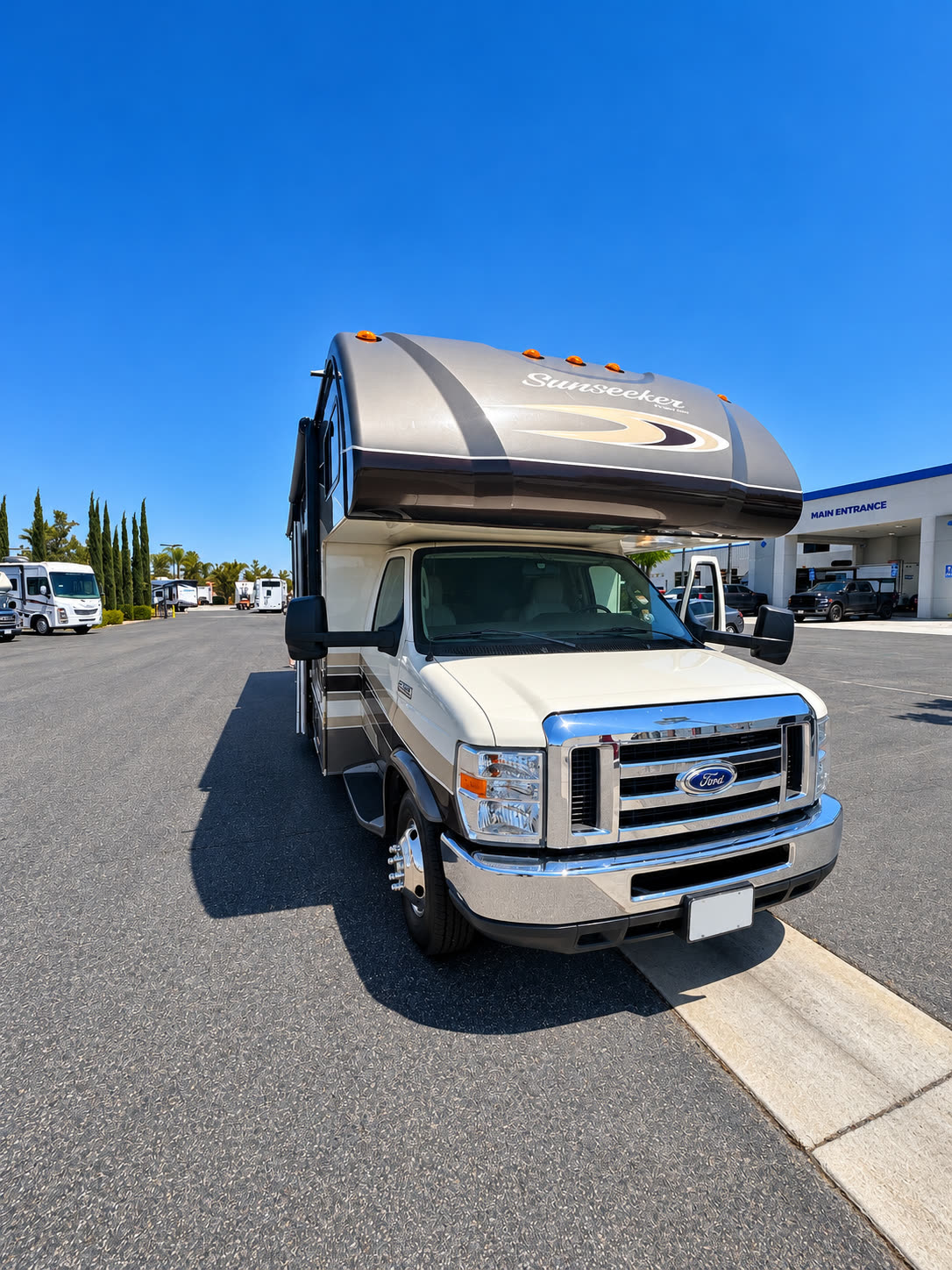 Front view of the Ford-based Sunseeker RV with chrome grille and cab-over sleeping section.