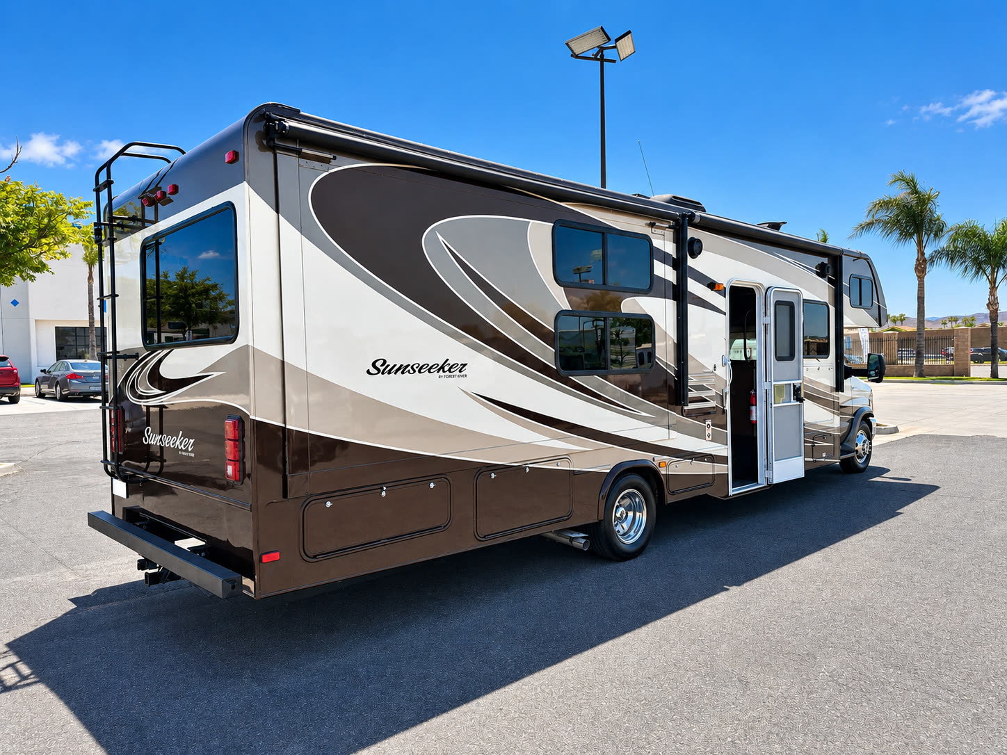Rear three-quarter exterior view of the Sunseeker RV with entry door, slide-out, and storage compartments.